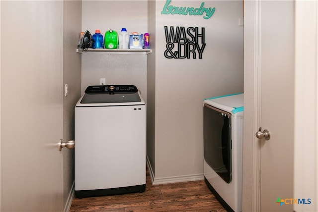 clothes washing area featuring separate washer and dryer and dark hardwood / wood-style flooring