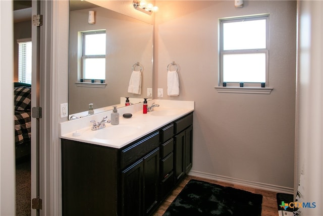 bathroom with wood-type flooring, a healthy amount of sunlight, and vanity