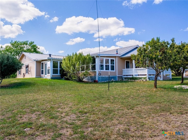 rear view of property featuring a yard