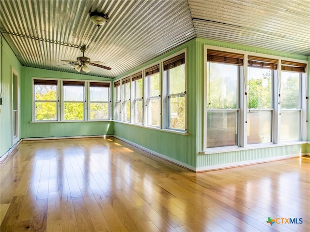 unfurnished sunroom featuring ceiling fan, plenty of natural light, and lofted ceiling