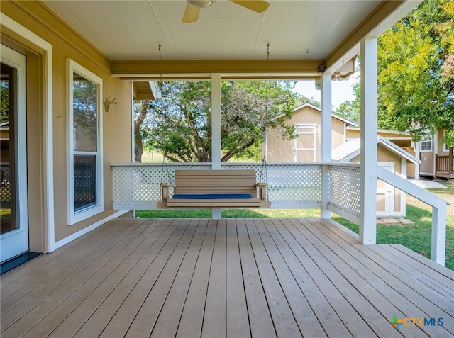 wooden terrace with a storage unit and ceiling fan