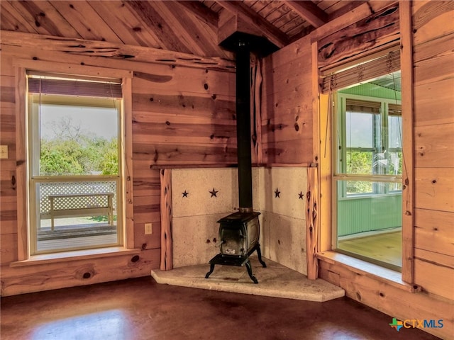 miscellaneous room with wooden ceiling, a healthy amount of sunlight, and a wood stove