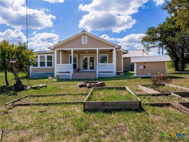 rear view of house with a lawn, an outbuilding, and ceiling fan