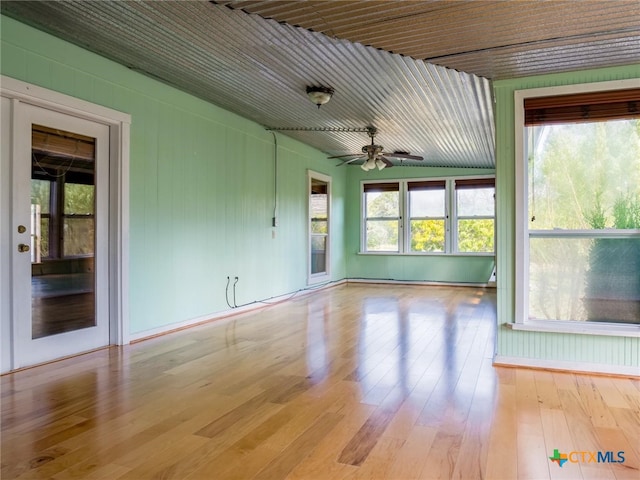 unfurnished sunroom featuring a wealth of natural light and ceiling fan