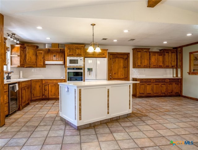 kitchen featuring a kitchen island, pendant lighting, white appliances, and tasteful backsplash