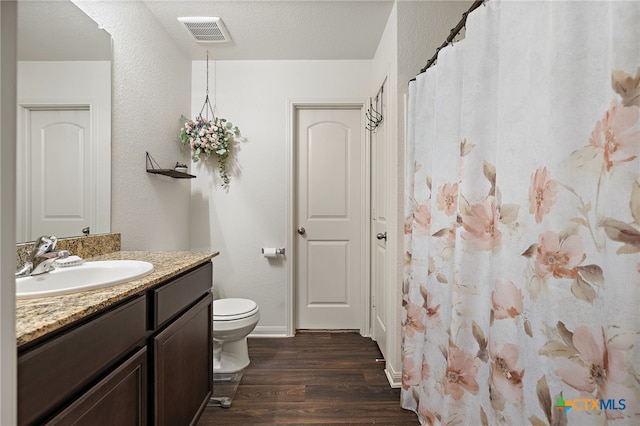 bathroom featuring hardwood / wood-style flooring, a textured ceiling, toilet, and vanity