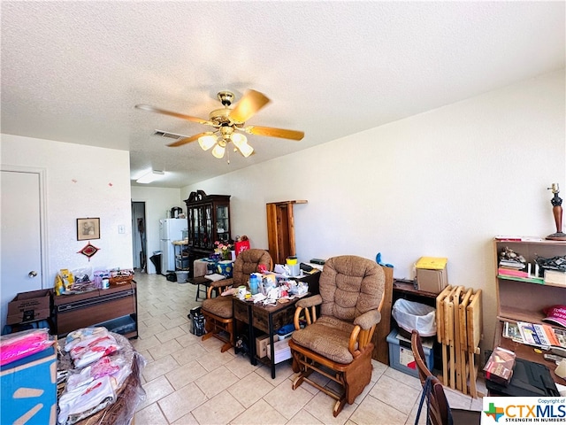 interior space with ceiling fan and a textured ceiling