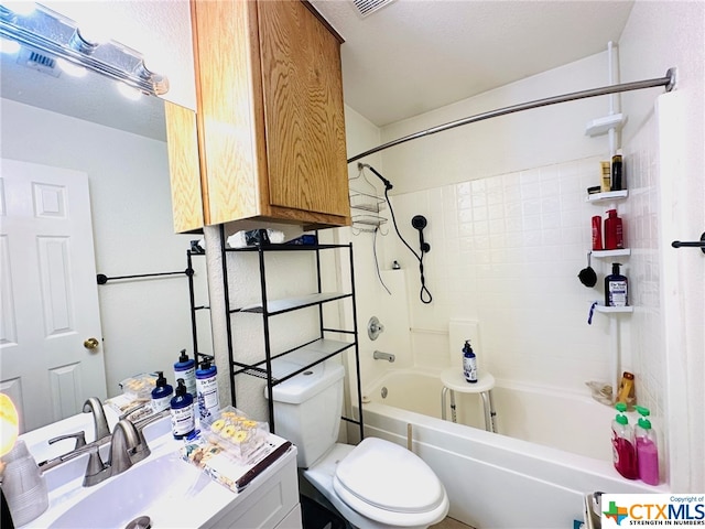 full bathroom featuring vanity, tiled shower / bath, and toilet