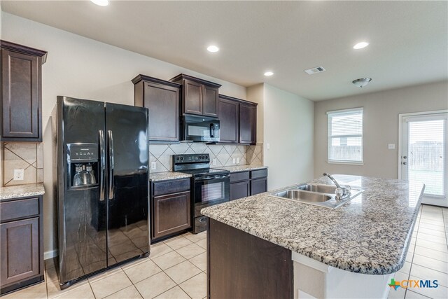 kitchen with black appliances, sink, dark brown cabinets, and a kitchen island with sink