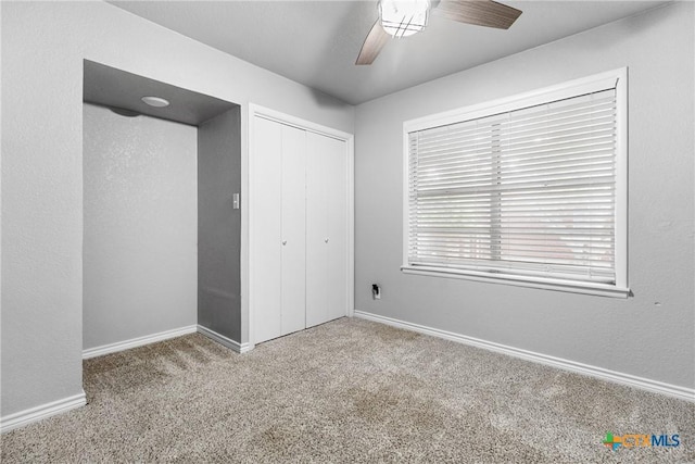 unfurnished bedroom featuring a closet, carpet flooring, baseboards, and ceiling fan