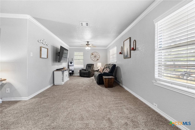living area with ceiling fan, carpet, baseboards, ornamental molding, and visible vents