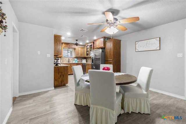 dining area featuring baseboards, light wood-style floors, and ceiling fan