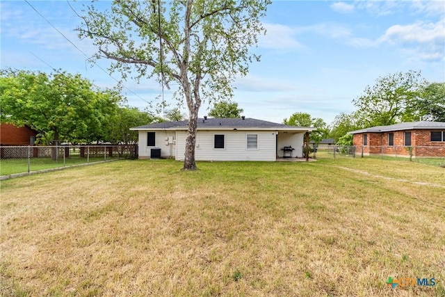 rear view of house with a yard, a fenced backyard, and central AC unit