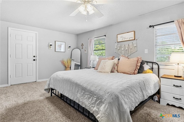 carpeted bedroom featuring baseboards and a ceiling fan