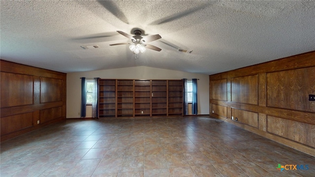 spare room featuring ceiling fan, a textured ceiling, and lofted ceiling