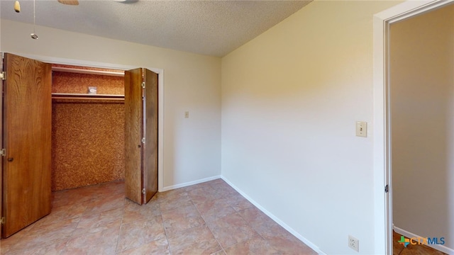 unfurnished bedroom featuring a textured ceiling, ceiling fan, and a closet