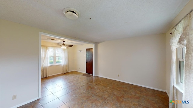 spare room featuring ceiling fan and a textured ceiling