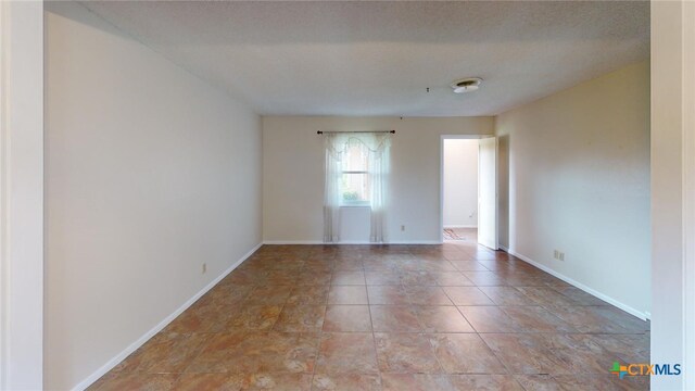 unfurnished room with a textured ceiling