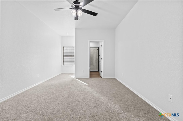 unfurnished bedroom featuring ceiling fan, ensuite bath, and light carpet