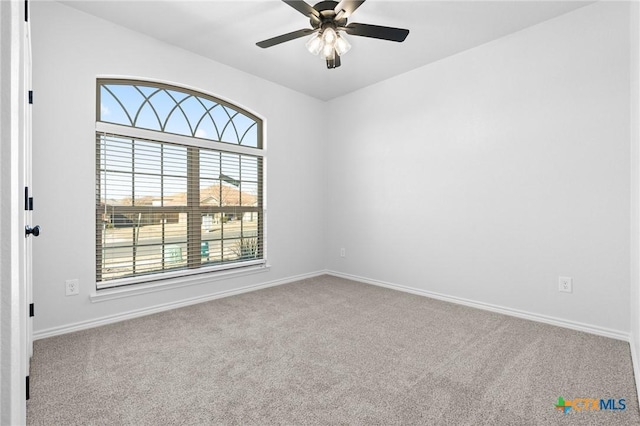 carpeted spare room with ceiling fan