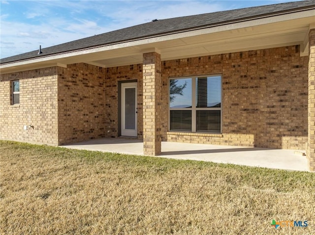 rear view of house featuring a patio and a lawn