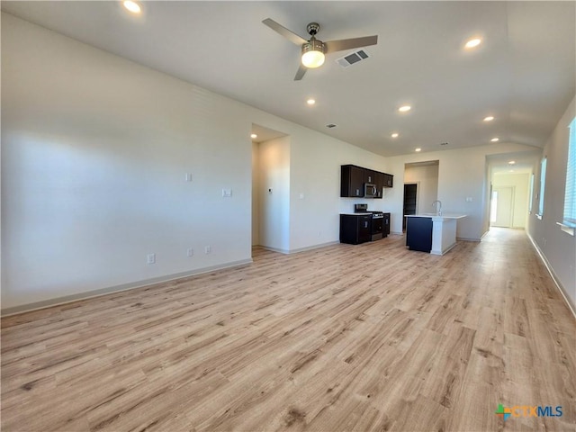 unfurnished living room with sink, light hardwood / wood-style floors, and ceiling fan