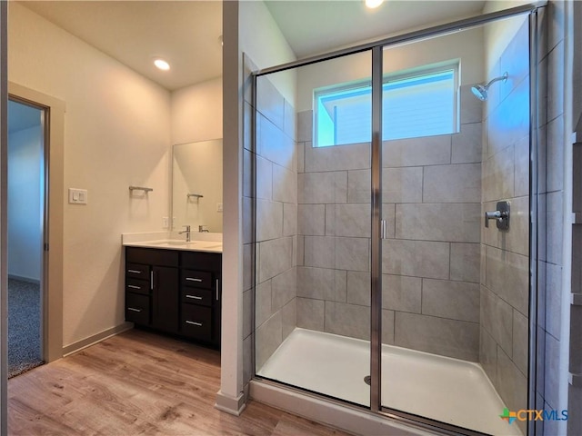 bathroom with a shower with door, vanity, and hardwood / wood-style floors