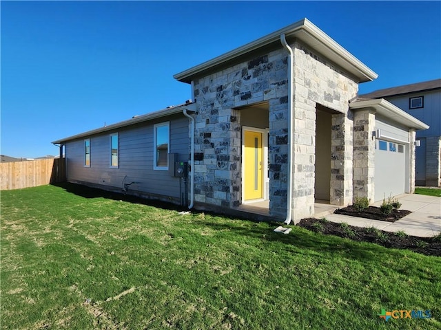 back of house with a yard and a garage