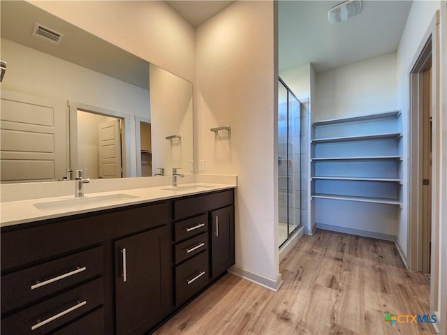 bathroom with an enclosed shower, wood-type flooring, and vanity