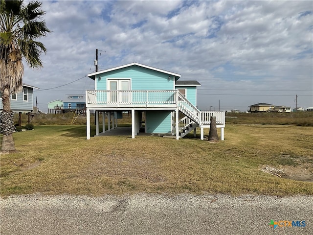 view of front facade featuring a front yard and a wooden deck