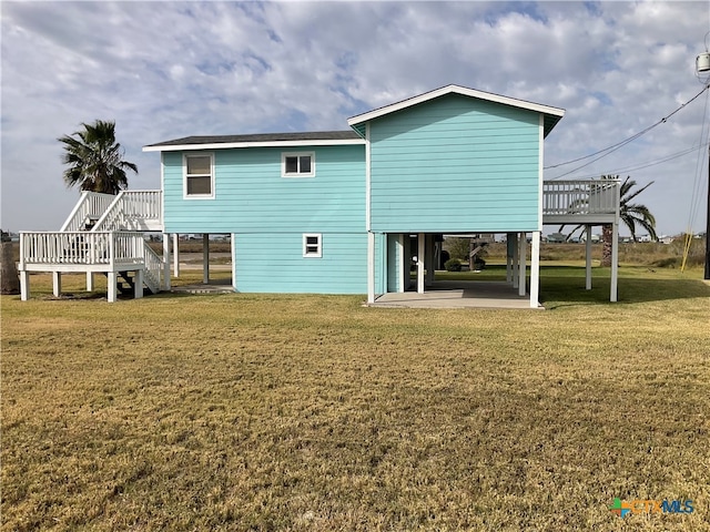 rear view of property featuring a wooden deck and a yard