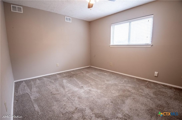 carpeted empty room with ceiling fan and a textured ceiling