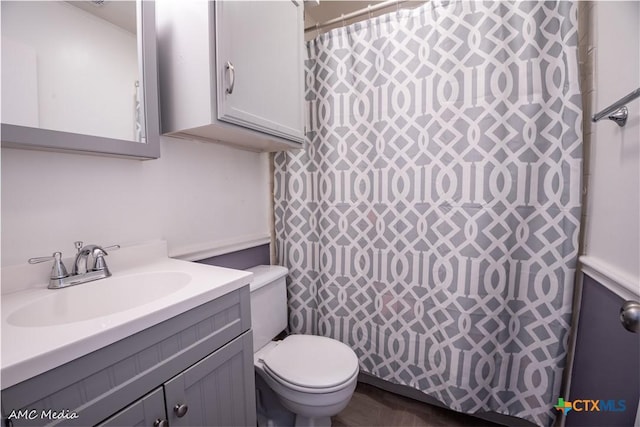 bathroom featuring walk in shower, vanity, and toilet