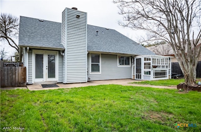 back of property featuring a patio, a sunroom, a yard, and french doors