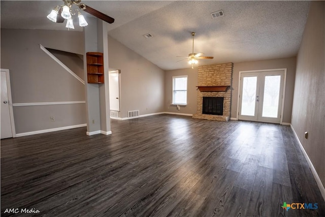 unfurnished living room featuring lofted ceiling, a textured ceiling, dark hardwood / wood-style flooring, ceiling fan, and a fireplace