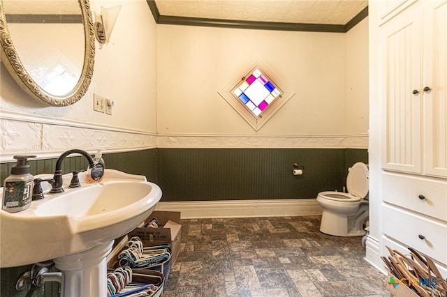 204 Ave F, Shiner, TX 77984 - half bath featuring toilet, crown molding, and a wainscoted wall
