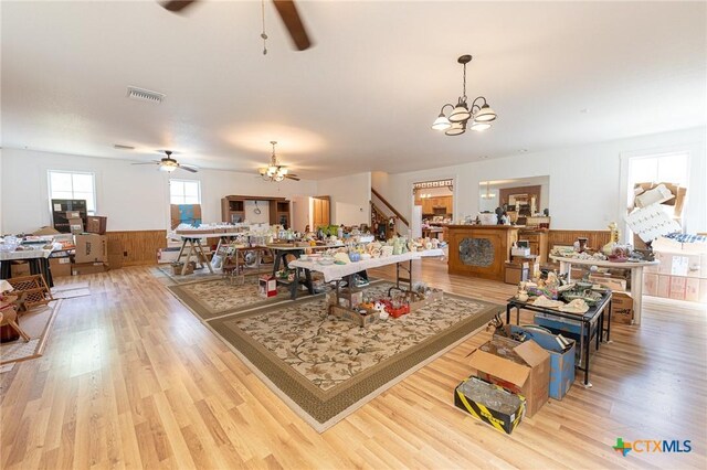 204 Ave F, Shiner, TX 77984 - living area with wainscoting, visible vents, wood finished floors, and ceiling fan with notable chandelier