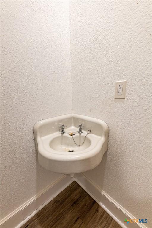 204 Ave F, Shiner, TX 77984 - bathroom featuring a textured wall and wood finished floors