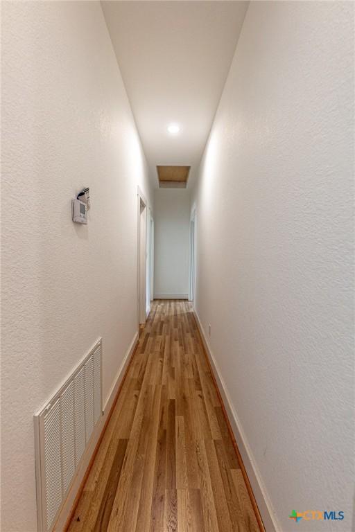 204 Ave F, Shiner, TX 77984 - hallway with baseboards, light wood-type flooring, and visible vents