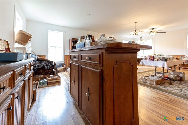 204 Ave F, Shiner, TX 77984 - kitchen with hanging light fixtures, a notable chandelier, a center island, and light wood-style floors