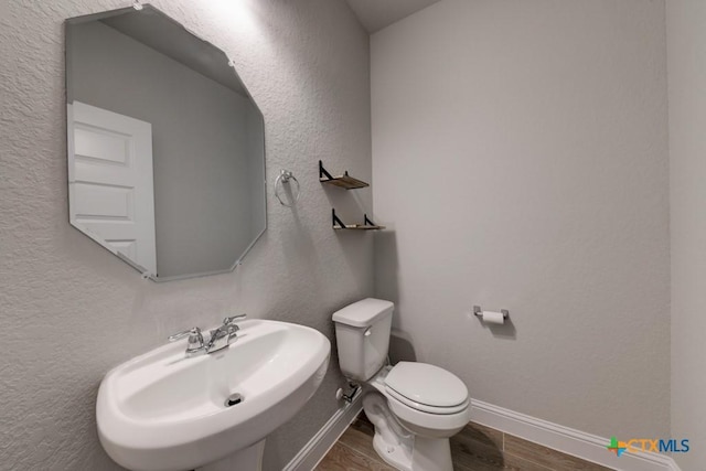 bathroom with sink, wood-type flooring, and toilet