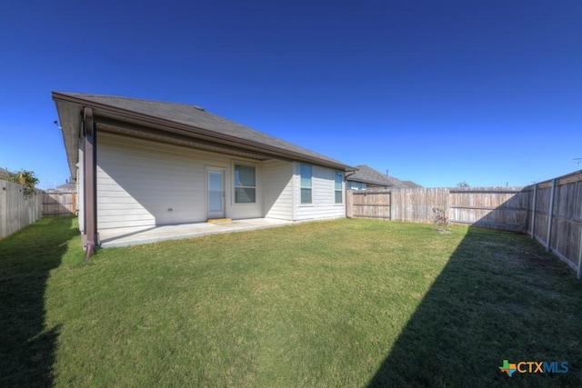 rear view of house featuring a yard and a patio