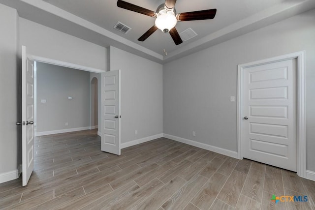 spare room with ceiling fan and light wood-type flooring