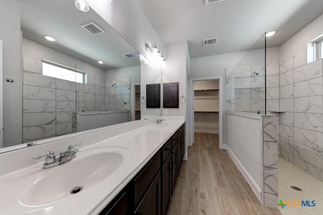 bathroom featuring a tile shower, hardwood / wood-style floors, and vanity