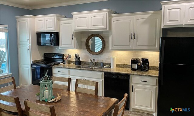 2790 Fm 2031, Matagorda, TX 77457 - kitchen with black appliances, a sink, white cabinets, dark stone counters, and ornamental molding
