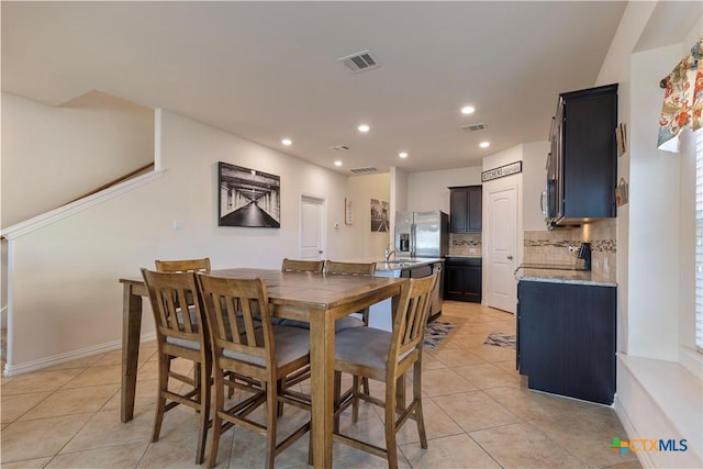 dining space with light tile patterned floors and sink