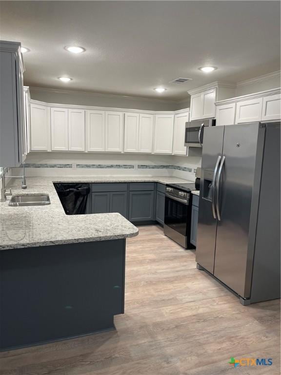 kitchen featuring white cabinets, stainless steel appliances, ornamental molding, and sink