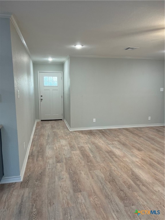 interior space featuring crown molding and light hardwood / wood-style flooring