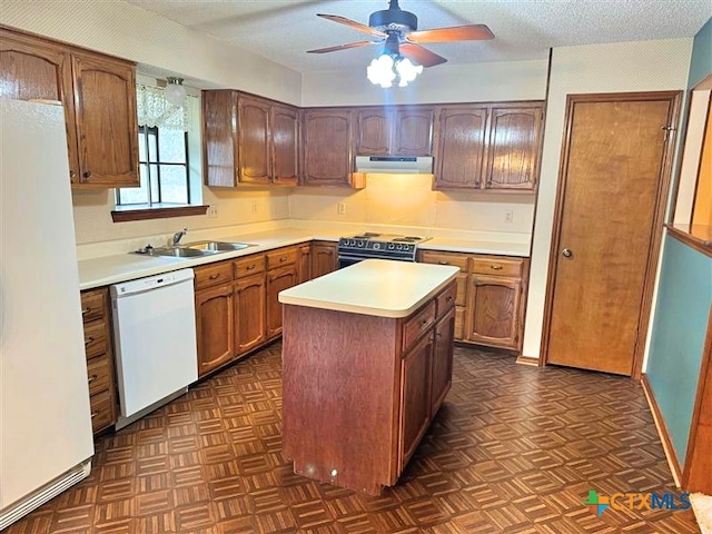 kitchen with a textured ceiling, white appliances, ceiling fan, sink, and a kitchen island