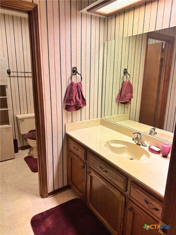 bathroom with tile patterned flooring, vanity, and toilet